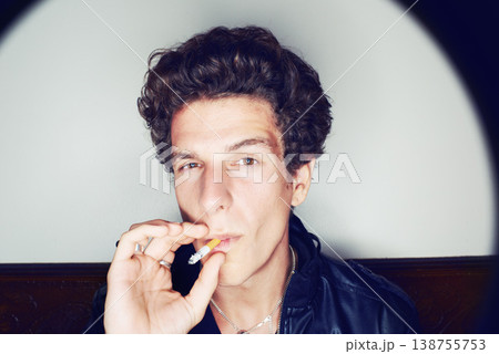 Portrait of man with cigarette, grunge fashion and rockstar attitude on white background with spotlight. Cool rock style, modern creative and smoking, confident face of handsome male model in studio. Portrait of man with cigarette, grunge fashion and rockstar attitude on white background with spotlight. Cool rock style, modern creative and smoking, confident face of handsome male model in studio. 138755753