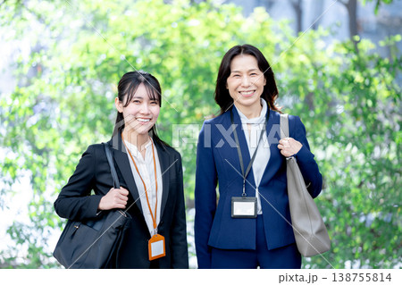 屋外で会話するビジネスウーマン 138755814