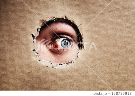 Closeup, cardboard and eye spy on hole, peek and search on mockup space. Face, macro and man peeping through paper board for secret, security and watch for surveillance, discover mystery and privacy Closeup, cardboard and eye spy on hole, peek and search on mockup space. Face, macro and man peeping through paper board for secret, security and watch for surveillance, discover mystery and privacy 138755918