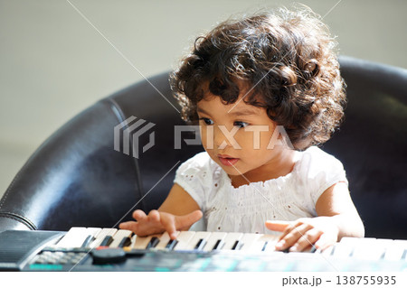 Girl, child and keyboard music play for childhood learning, education development or lessons. Female person, kid and piano keys song or instrument training knowledge, youth artist or future musician 138755935