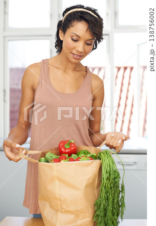 Kitchen, vegetables and woman with groceries, healthy food and wellness with retail, package and customer. Person, client and girl with nutrition, home and meal with brown bag, thinking and diet 138756002