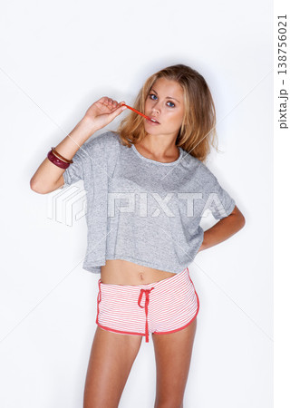 Fashion, candy and portrait of woman on a white background with trendy clothes, cool style and shorts. Aesthetic, confidence and isolated person in pajamas with sweets, dessert and treat in studio 138756021