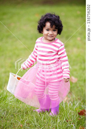 Portrait, happy child and tutu on grass in park with basket for leaves for autumn. Little girl, pink clothes and curly hair with rain boots for growth, development and changing of season for Easter Portrait, happy child and tutu on grass in park with basket for leaves for autumn. Little girl, pink clothes and curly hair with rain boots for growth, development and changing of season for Easter 138756202