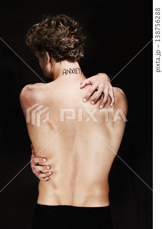 Back, anxiety and body of man in studio isolated on a black background. Rear view, worry and person with psychology trauma, mistake or fear, frustrated at depression and mental health tattoo or words 138756288