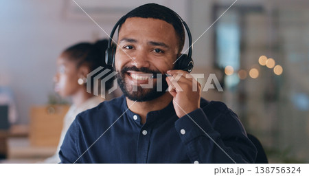 Portrait, smile and man at call center on headphones for crm support on bokeh at night. Face, happy sales agent on mic and telemarketing consultant, customer service professional or worker in office 138756324