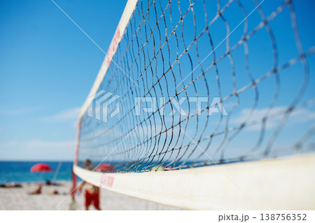 Volleyball, net and beach with blue sky outdoor for game, competition or match. Ocean, sports netting closeup or sand field for training, exercise and workout, fitness or sea for recreation in summer Volleyball, net and beach with blue sky outdoor for game, competition or match. Ocean, sports netting closeup or sand field for training, exercise and workout, fitness or sea for recreation in summer 138756352