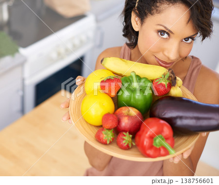 Portrait, fruit and vegetables with a woman in the kitchen of her home for nutrition, diet or meal preparation. Face, health and recipe ingredients for cooking food with a person in her apartment Portrait, fruit and vegetables with a woman in the kitchen of her home for nutrition, diet or meal preparation. Face, health and recipe ingredients for cooking food with a person in her apartment 138756601