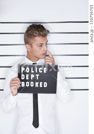 Crime, mugshot and man on a white background for suspect for criminal, illegal and fraud activity. Police station, height chart and person thinking with signboard for arrested, wanted and convict 138756705