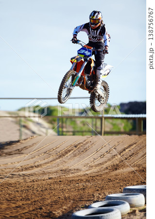 Person, motorcycle or bike jump on race track as professional in action competition, fearless or dust path. Rider, off road transportation for fast speed adventure or rally, extreme sport or gear Person, motorcycle or bike jump on race track as professional in action competition, fearless or dust path. Rider, off road transportation for fast speed adventure or rally, extreme sport or gear 138756767