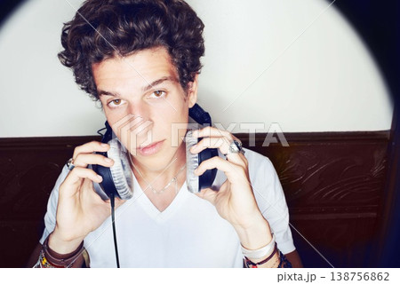 Portrait of man with headphones, rock dj and beats with rockstar attitude on white background with spotlight. Cool punk style, sound and music, club culture with face of male model with entertainment 138756862