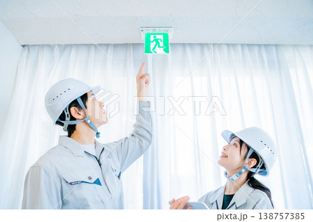 消防設備点検をする作業着の男女 138757385