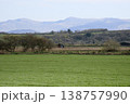 Tractor working on rural farmland with mountains in background 138757990