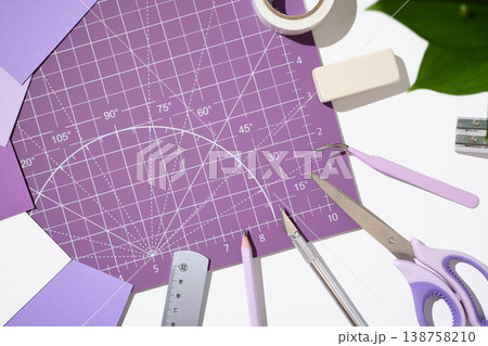 Top view of scrapbooking tools, scissors, and craft knife on a purple cutting mat. Copyspace Top view of scrapbooking tools, scissors, and craft knife on a purple cutting mat. Copyspace 138758210