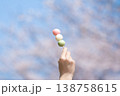 桜を背景に三色団子を持つ 花より団子のイメージ 138758615