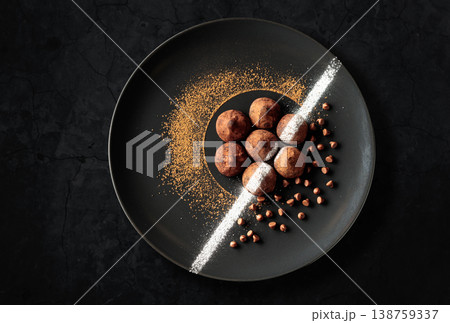 Chocolate truffles on a black plate. Chocolate truffles on a black plate. 138759337