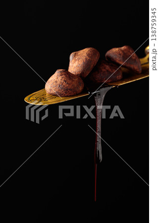 Chocolate truffles against a black background. Chocolate truffles against a black background. 138759345