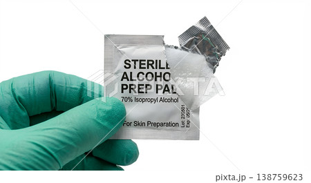 Gloved hand in medical glove holding sterile alcohol prep pad, representing skin antisepsis, injection preparation, and clinical hygiene 138759623
