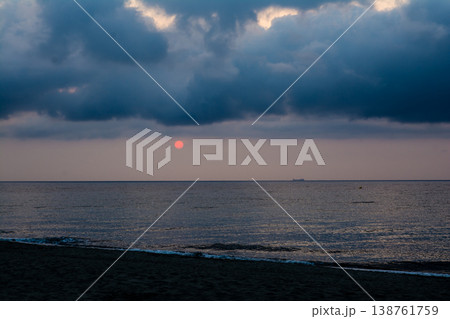 日の出前の海岸線から見える雲と海に挟まれたオレンジ色の空　地中海に浮かぶフランス領のコルシカ島にて 138761759