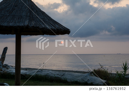海岸線から見える雲と海に挟まれた日の出とオレンジ色の空 地中海に浮かぶフランス領のコルシカ島にて 海岸線から見える雲と海に挟まれた日の出とオレンジ色の空 地中海に浮かぶフランス領のコルシカ島にて 138761932