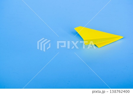 Single yellow paper airplane flying alone through an open gradient blue background with customizable space for text or ideas Single yellow paper airplane flying alone through an open gradient blue background with customizable space for text or ideas 138762400