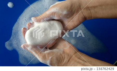 Hands holding soap with bubbles in a blue setting during cleaning process Hands holding soap with bubbles in a blue setting during cleaning process 138762429