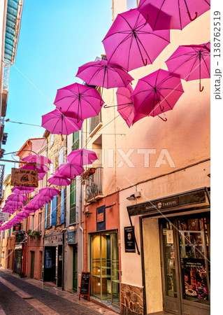 Pink umbrellas hanging in the streets of Collioure in France. Pink umbrellas hanging in the streets of Collioure in France. 138762519