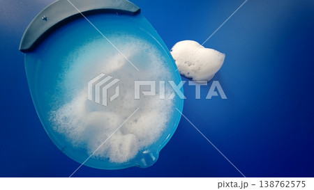 Bowl with soap foam on blue background while cleaning surfaces 138762575