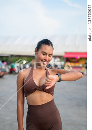 Thai Fitness Influencer Checking Smartwatch at Tropical Outdoor Market Modern Digital Lifestyle Concept 138763045