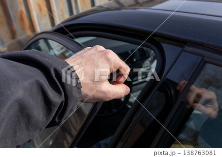 A man opens a sleek car door, showcasing modern design and urban life, set against the backdrop of a lively city street A man opens a sleek car door, showcasing modern design and urban life, set against the backdrop of a lively city street 138763081