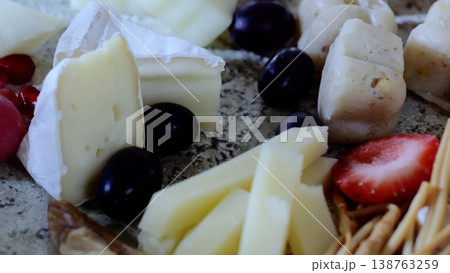 Artisan cheese selection displaying creamy, aged varieties alongside fresh fruits, pomegranate seeds, and crisp breadsticks, showcasing elegant appetizer presentation Artisan cheese selection displaying creamy, aged varieties alongside fresh fruits, pomegranate seeds, and crisp breadsticks, showcasing elegant appetizer presentation 138763259