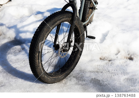 Closeup of winter bike features. Cycling through snow showing rugged tires and icy shadows 138763488