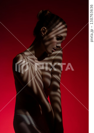 Striking elegance of a nude model with dramatic lighting and shadows Striking elegance of a nude model with dramatic lighting and shadows 138763636