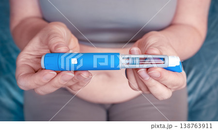 woman injecting a GLP-1 weight loss medication into belly fat woman injecting a GLP-1 weight loss medication into belly fat 138763911
