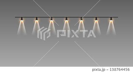 Row of track spotlights illuminating space with warm light beams Row of track spotlights illuminating space with warm light beams 138764456