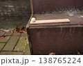 Wooden ruler with white ball on stone steps beside brick pavement with fallen leaves 138765224