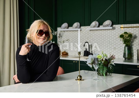 White woman hostess poised at marble counter with champagne 138765454
