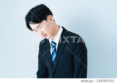 頭を抱えるスーツ姿の若い男性 138765532