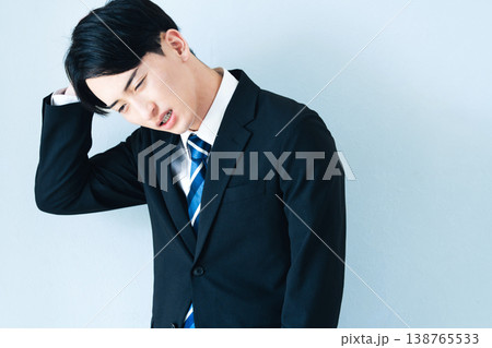 頭を抱えるスーツ姿の若い男性 138765533