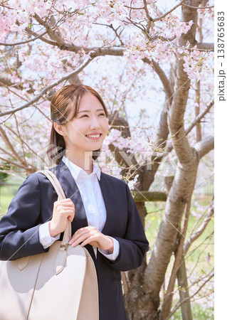 桜の下で微笑むリクルートスーツ姿の若い女性・春の新生活イメージ・新入社員の入社式 桜の下で微笑むリクルートスーツ姿の若い女性・春の新生活イメージ・新入社員の入社式 138765683
