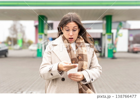 Fuel inflation concept woman shocked by gas receipt Fuel inflation concept woman shocked by gas receipt 138766477