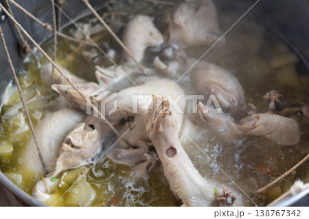 Close up of whole chicken boiling in broth for chicken rice rich soup texture traditional cooking process tender meat asian cuisine preparation 138767342