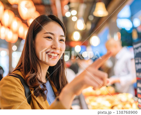 屋台で注文をする笑顔のかわいい若い女性 138768900