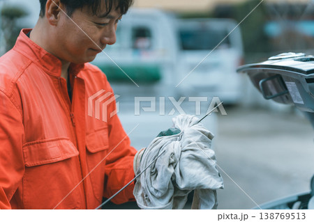 クルマのオイル状態を確認する自動車整備士 138769513