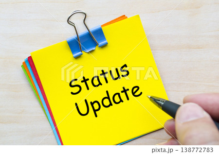 Status update written on yellow sticky note representing reporting and workflow communication Status update written on yellow sticky note representing reporting and workflow communication 138772783