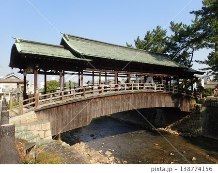 香川県仲多度郡琴平町を流れる金倉川に架かる刀の鞘のような反りがある形をした屋根がある鞘橋（さやばし） 138774156