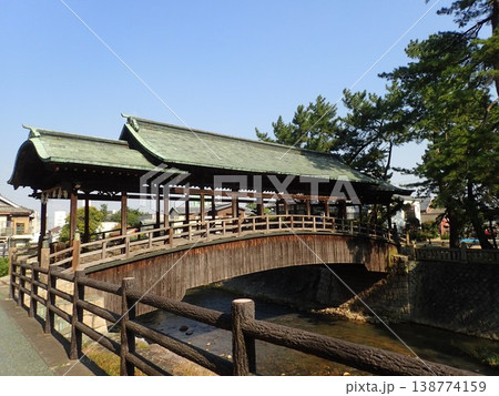 香川県仲多度郡琴平町を流れる金倉川に架かる刀の鞘のような反りがある形をした屋根がある鞘橋（さやばし） 138774159