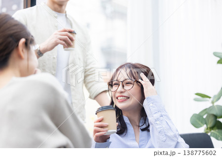 コーヒーを飲みながら話をするビジネスパーソン 138775602