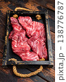 Closeup raw skirt beef steak with visible fibers and marbling on dark wooden background with rosemary and spices, uncooked protein ingredient for grilling 138776787