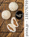 Asian steamed buns with meat filling cut open and served with dipping sauce, soft fluffy bao bread on wooden background 138776799