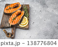Cooked salmon steaks including sockeye with herbs citrus and seasoning on board, clean light background 138776804